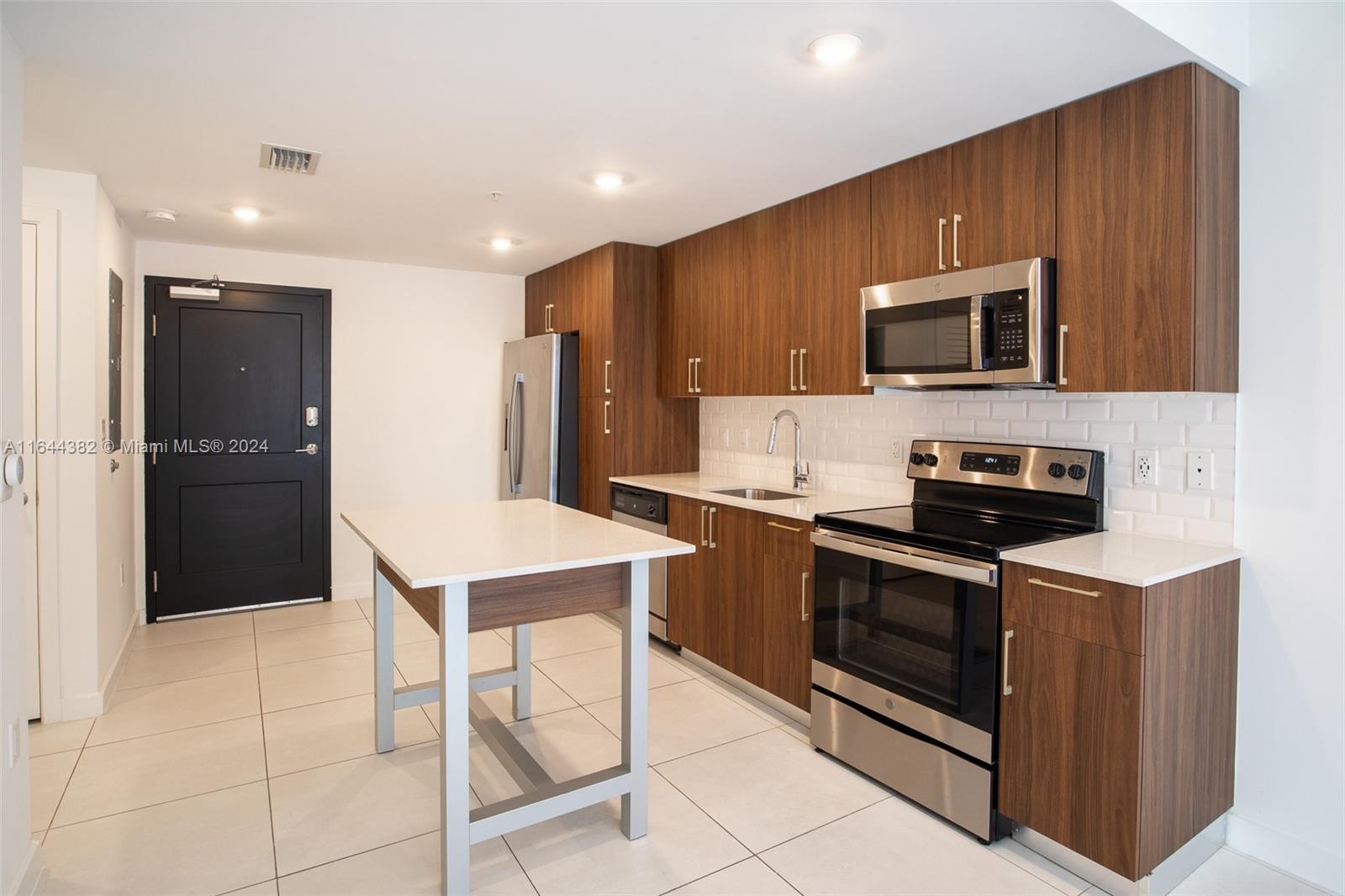 a kitchen with stainless steel appliances granite countertop a stove a sink and a microwave