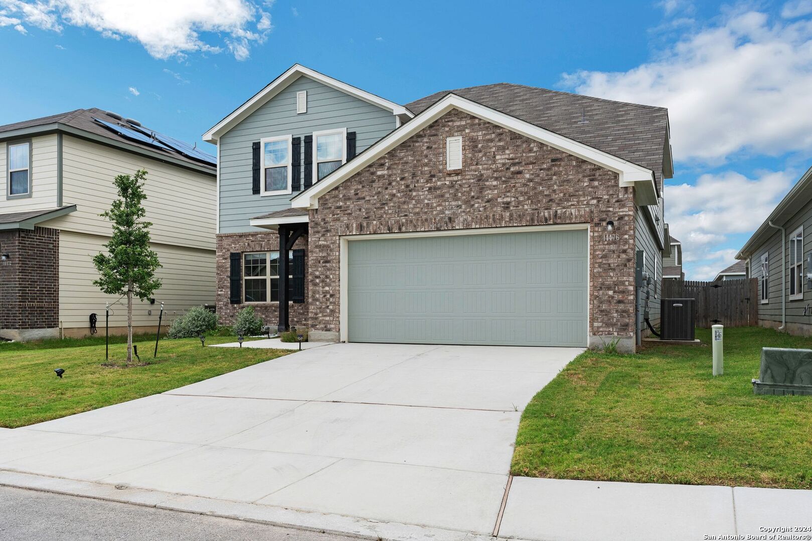 a front view of a house with a yard and garage