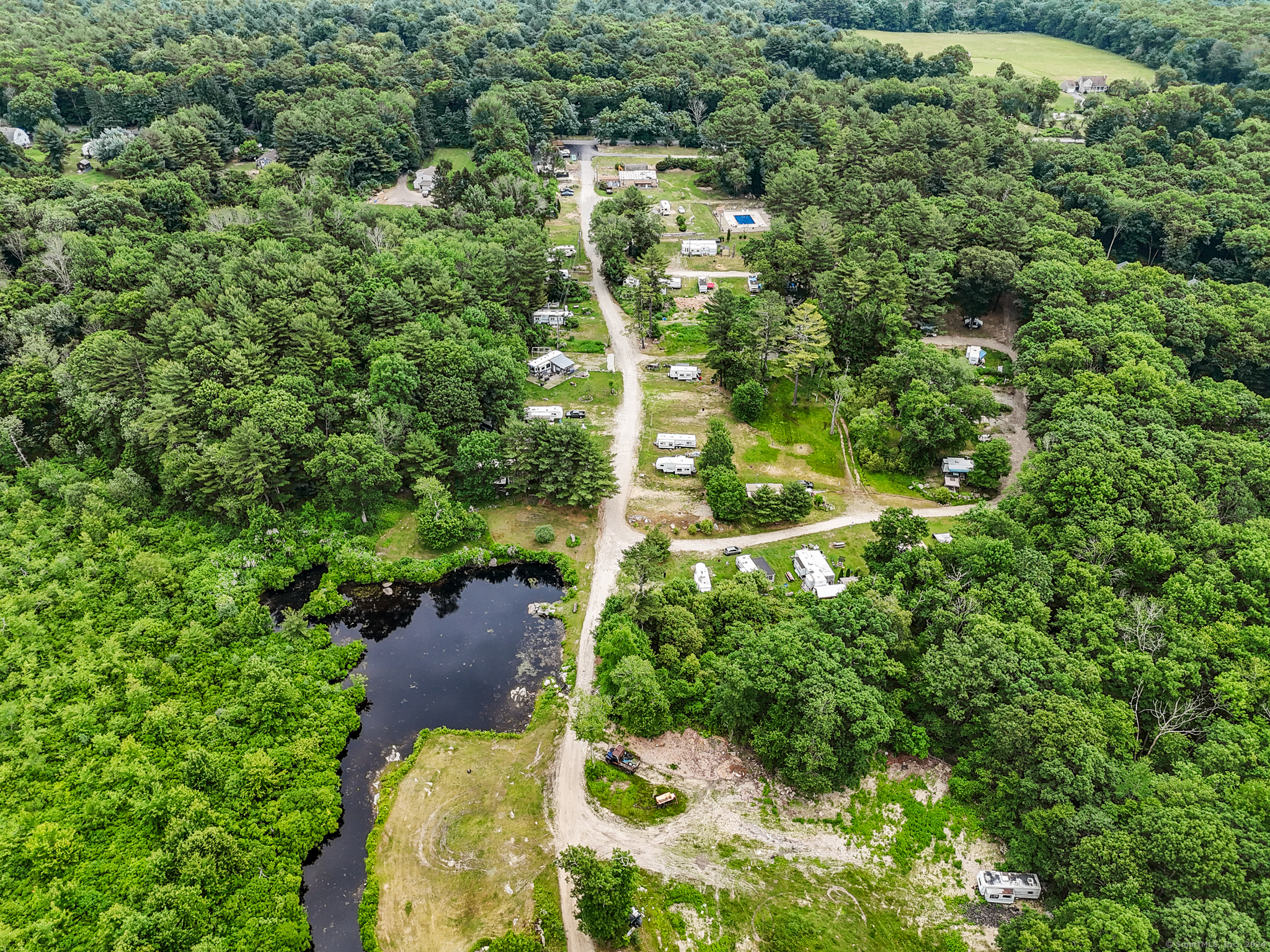 an aerial view of residential houses with outdoor space and trees