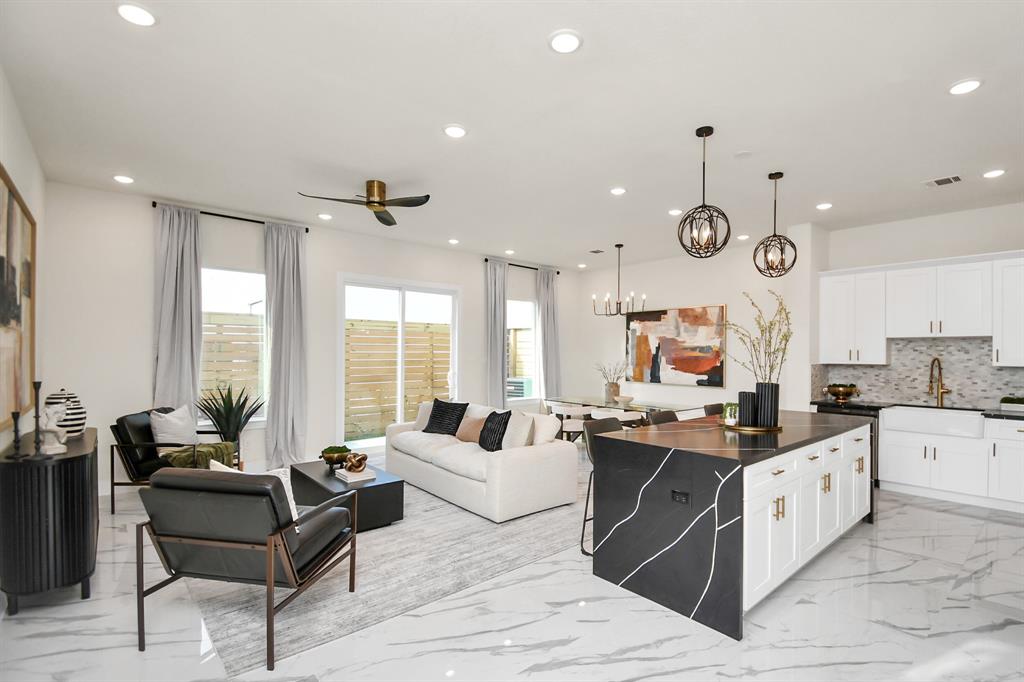 a large white kitchen with a large window and cabinets