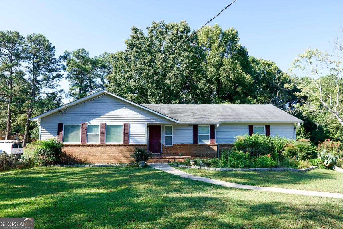 a front view of a house with a yard and trees