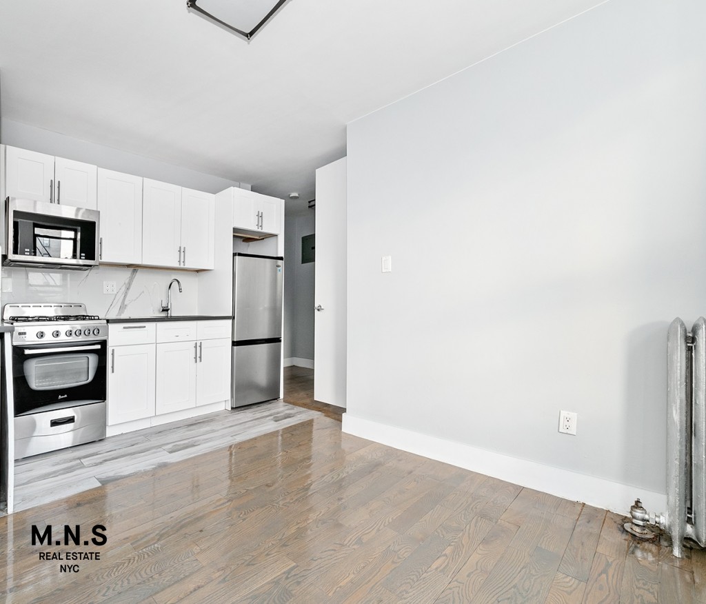 a kitchen with granite countertop white cabinets and stainless steel appliances