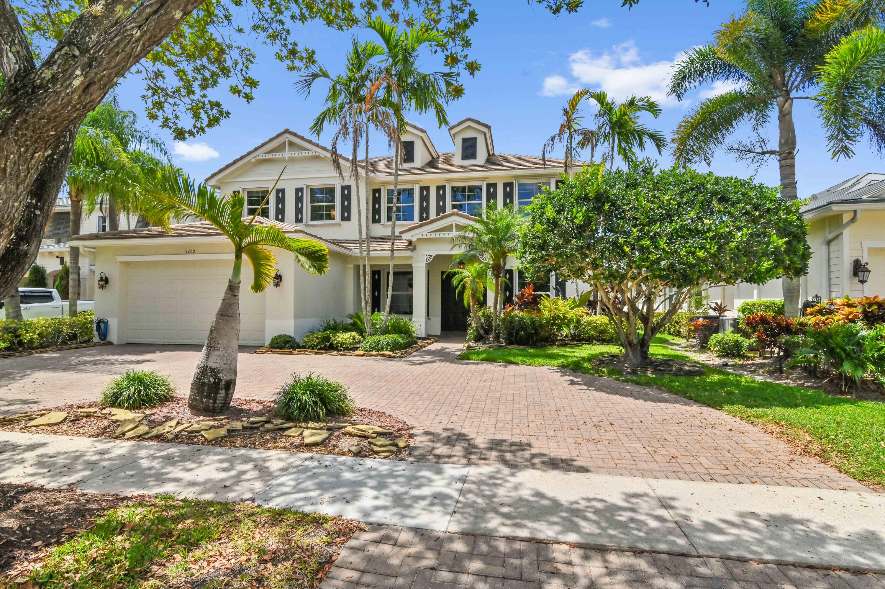 a front view of a house with a yard and tree s