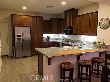 a kitchen with kitchen island a counter top space cabinets and stainless steel appliances