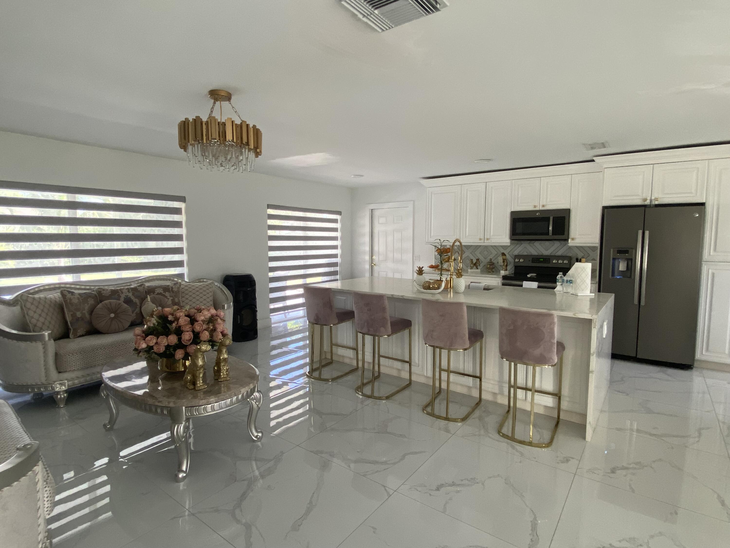 a kitchen with stainless steel appliances kitchen island granite countertop a table chairs and a refrigerator