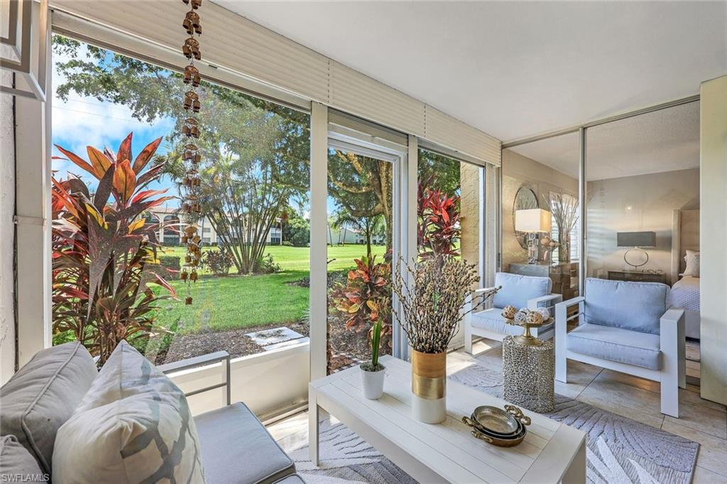 a living room with patio furniture and a garden