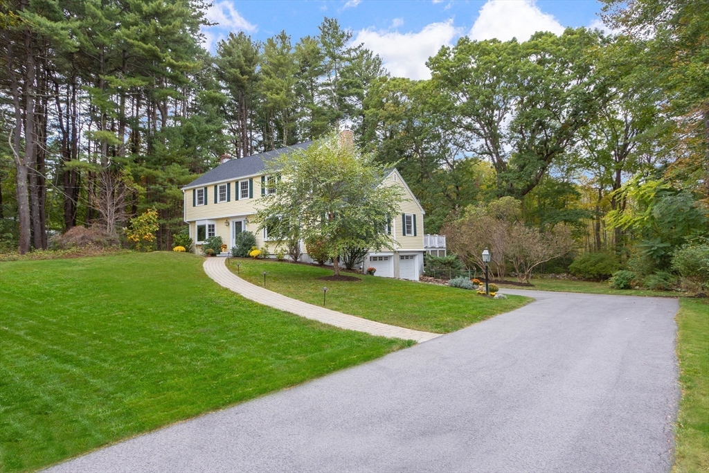 a view of a house with a yard and tree s