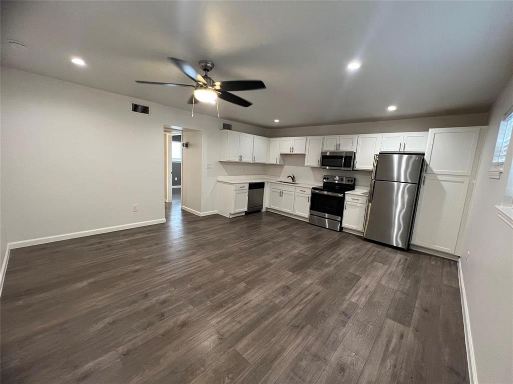 a view of kitchen with stainless steel appliances refrigerator stove microwave and cabinets