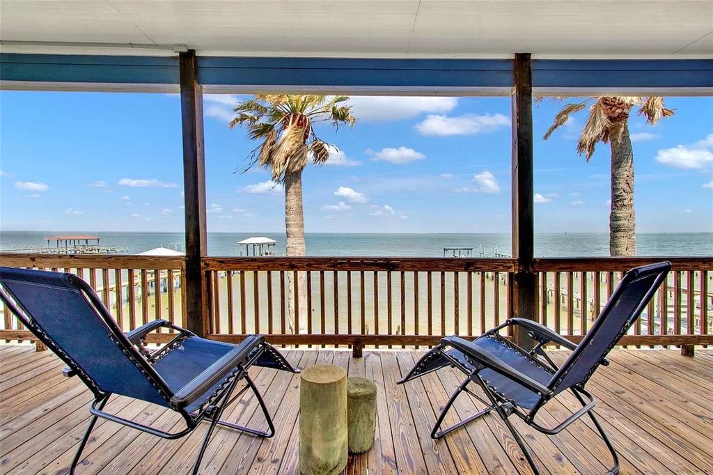 a view of a balcony with furniture and wooden floor