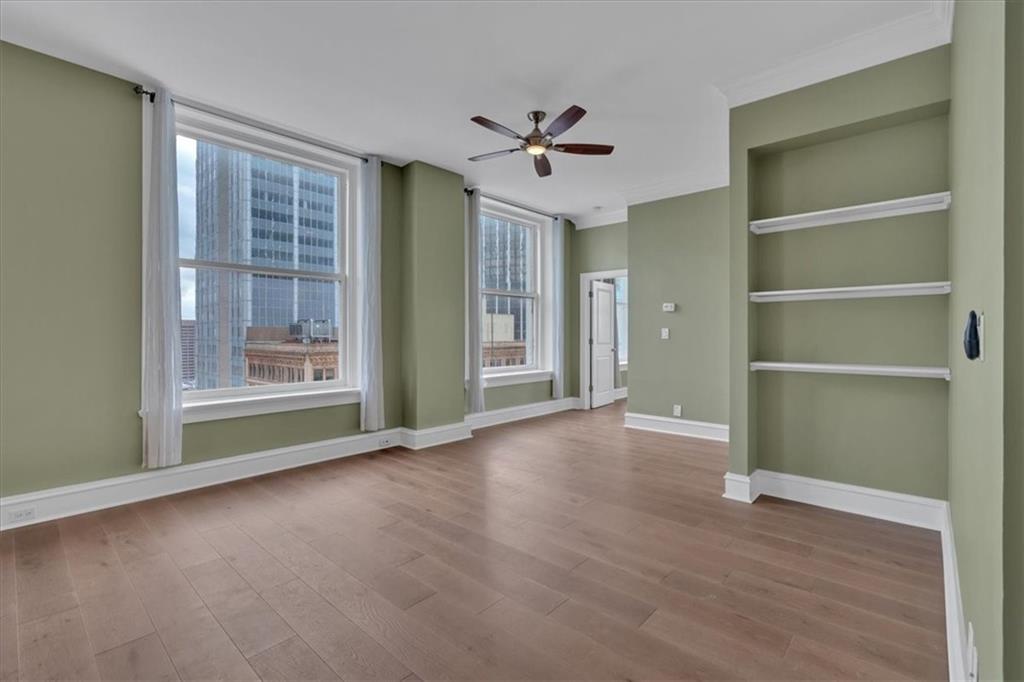 a view of an empty room with a window and wooden floor