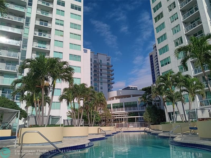 a view of swimming pool with outdoor seating and house in the background