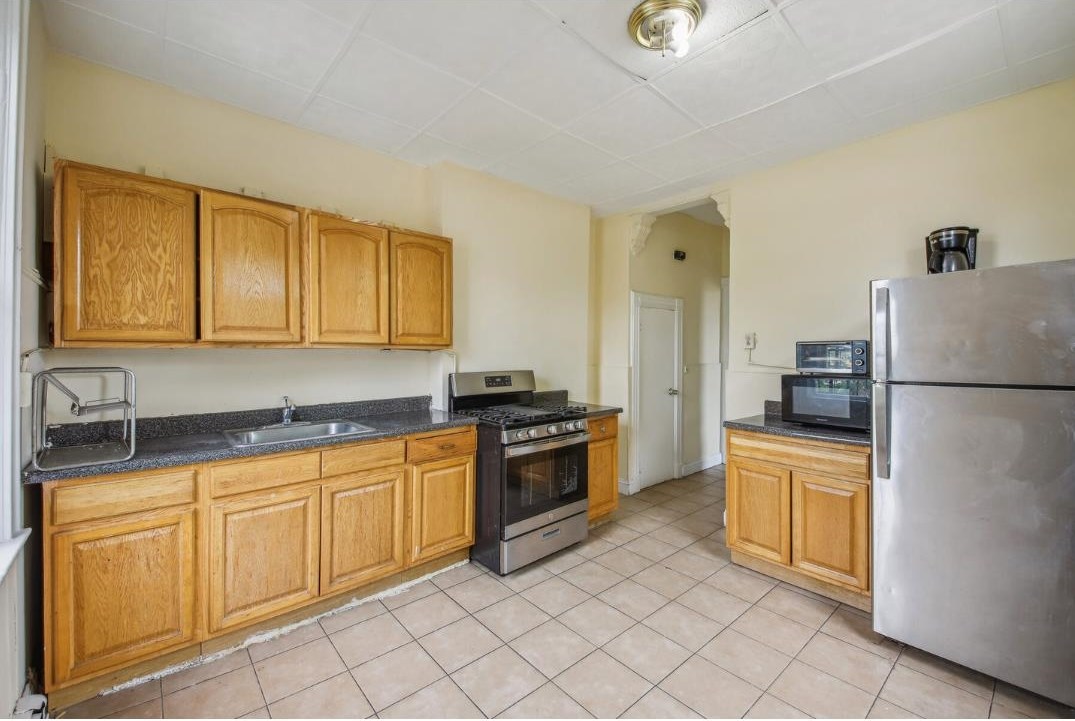 a kitchen with stainless steel appliances granite countertop a refrigerator sink and stove