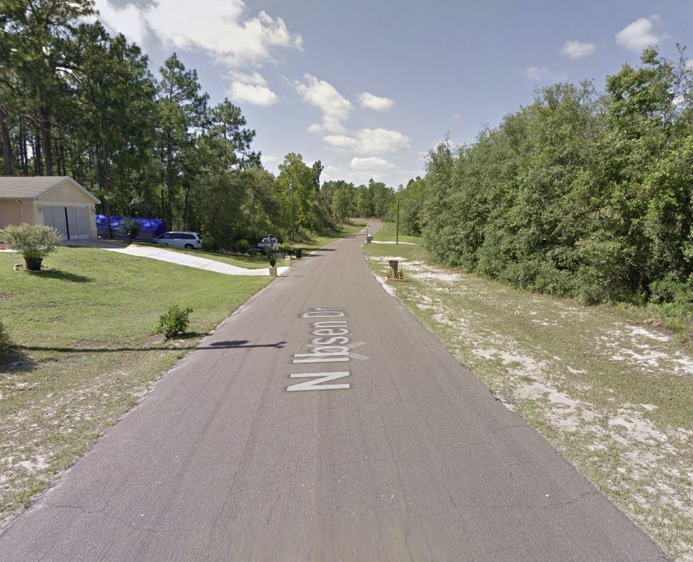 a view of a street with a yard