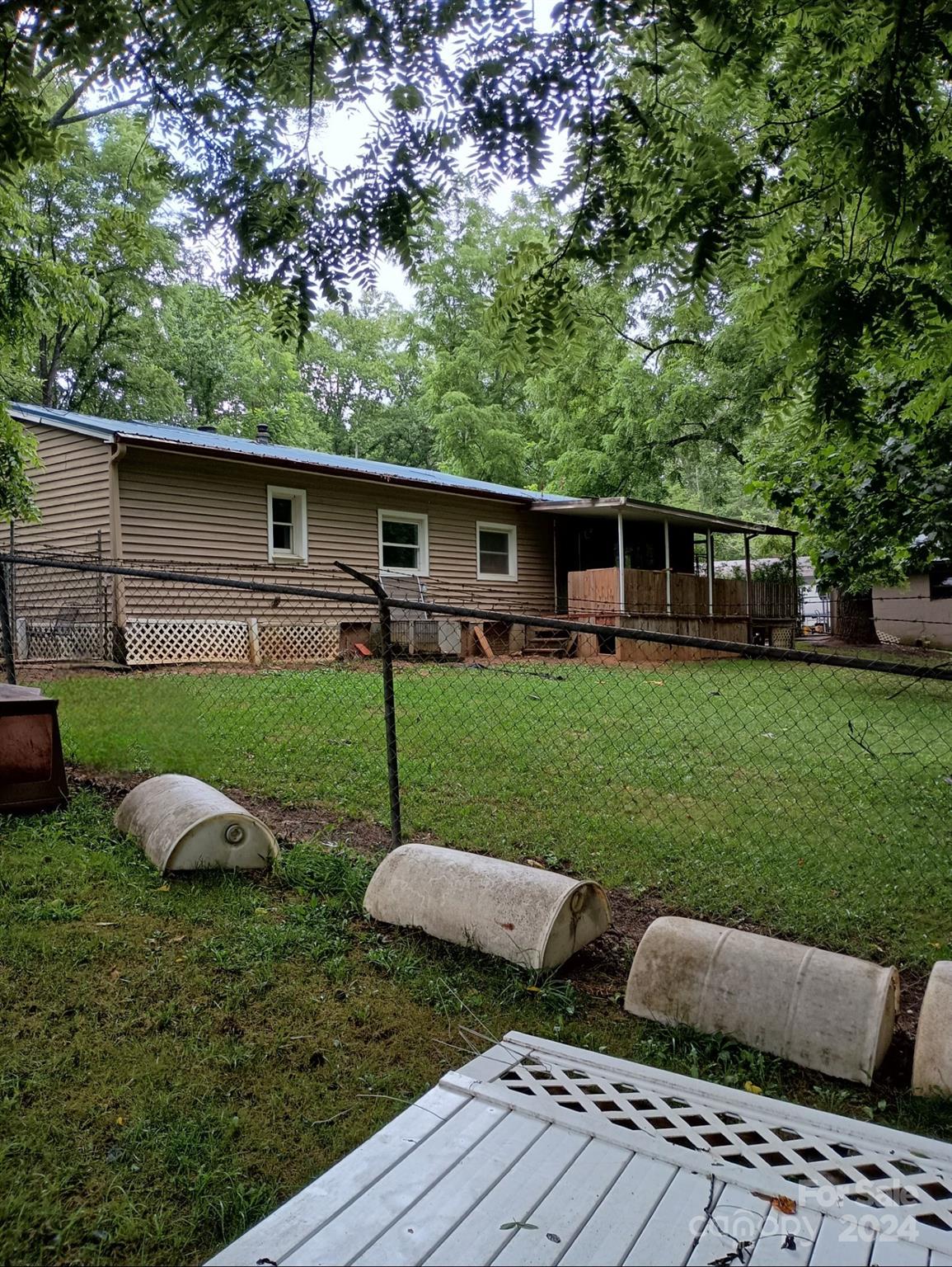 a view of a backyard with sitting area and tree