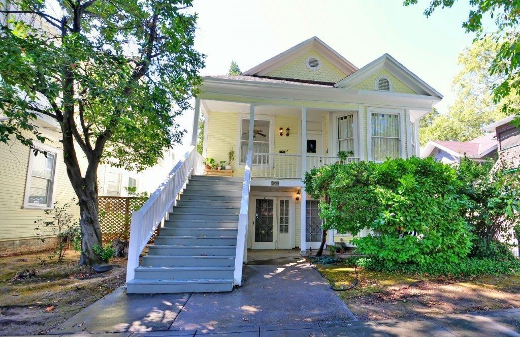 a front view of a house with wooden stairs and fence