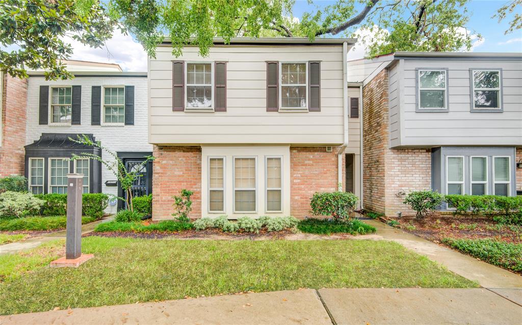 front view of a brick house with a yard