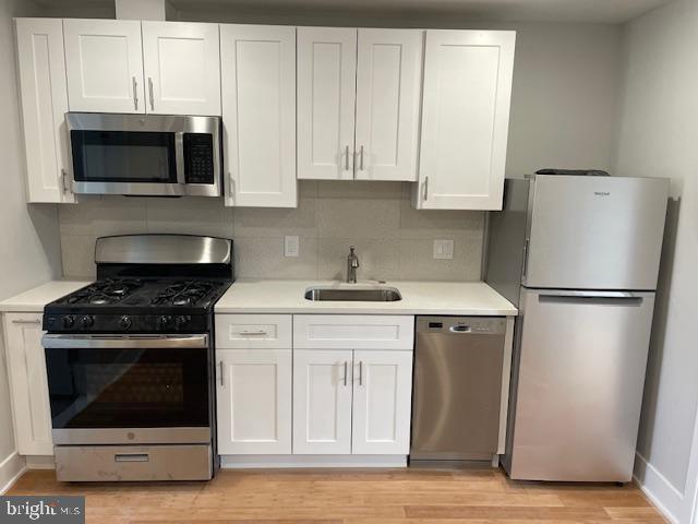 a kitchen with stainless steel appliances a stove a microwave and a sink