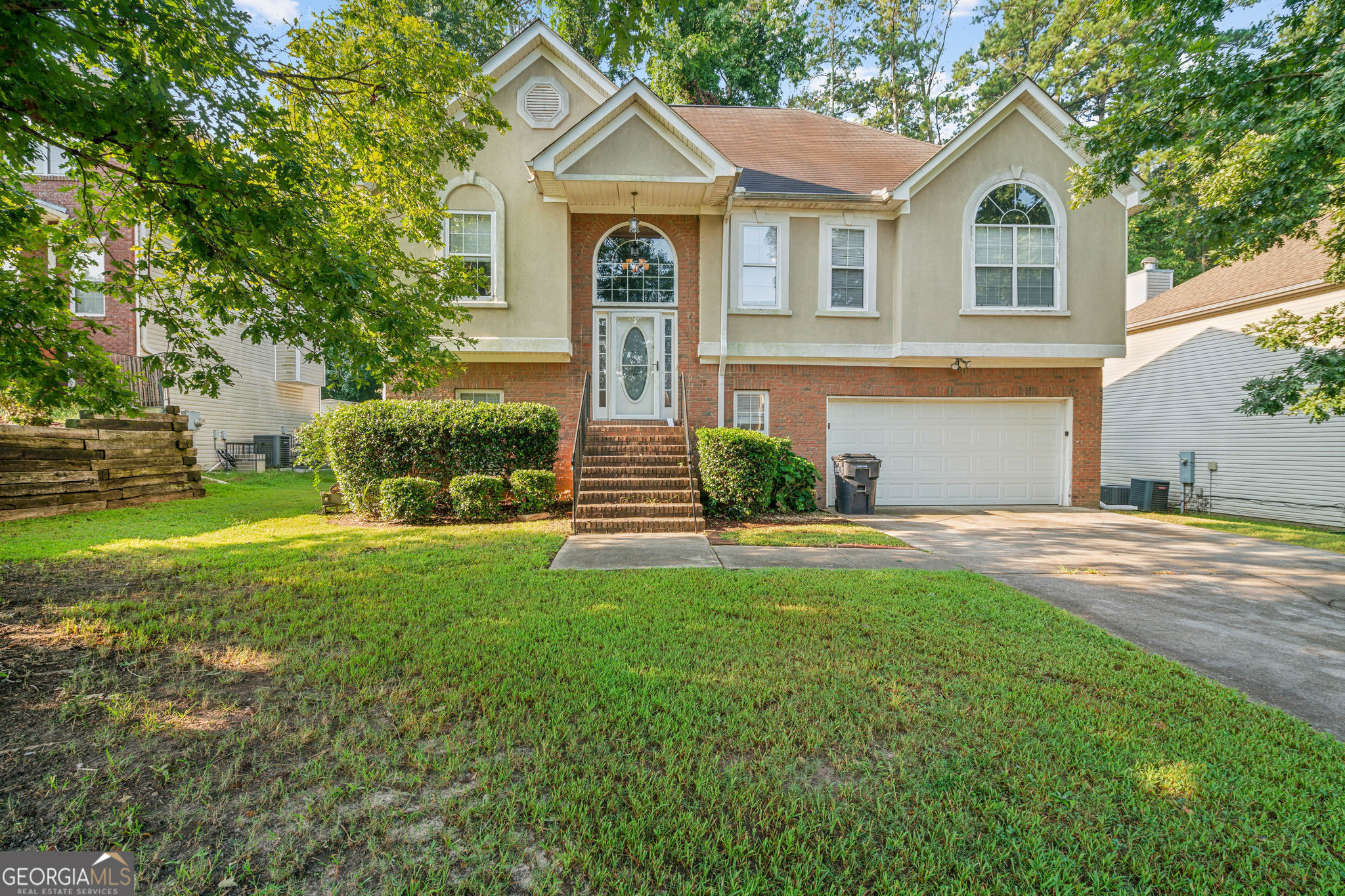 a front view of a house with a yard and trees