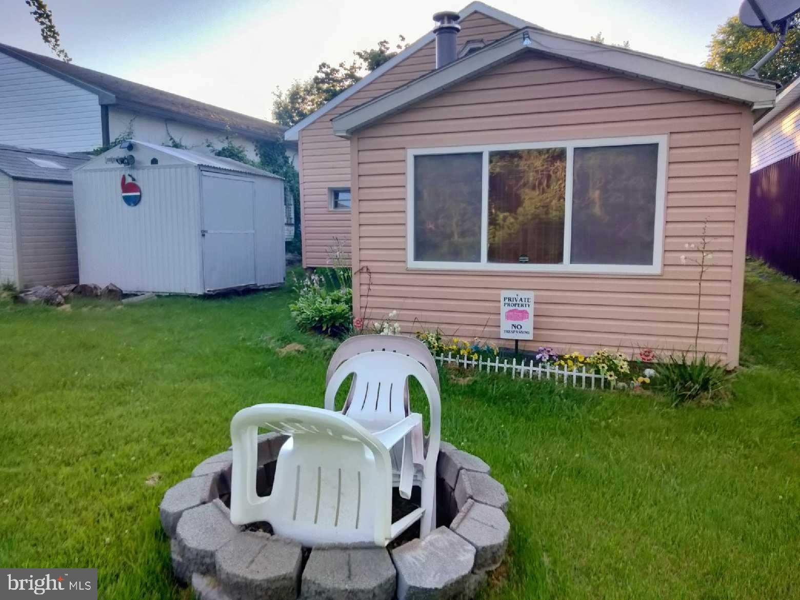 a view of a chair and table in backyard of the house