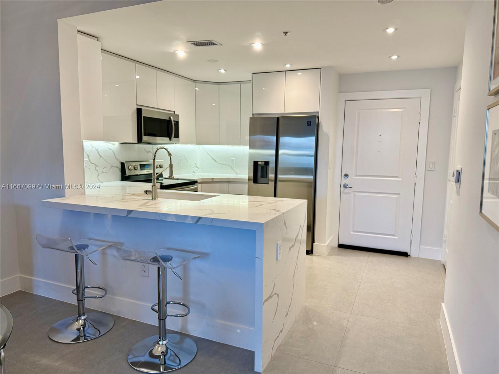 a kitchen with stainless steel appliances refrigerator and microwave