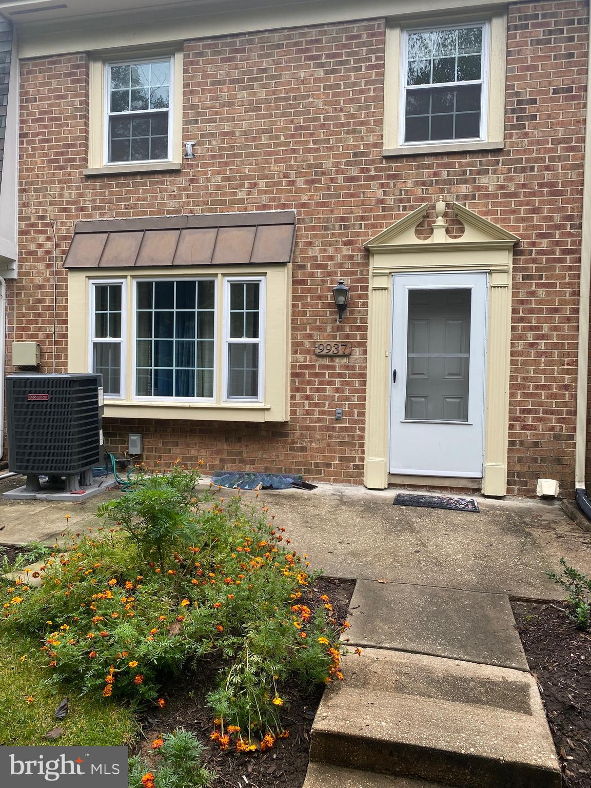 front view of a brick house with a yard