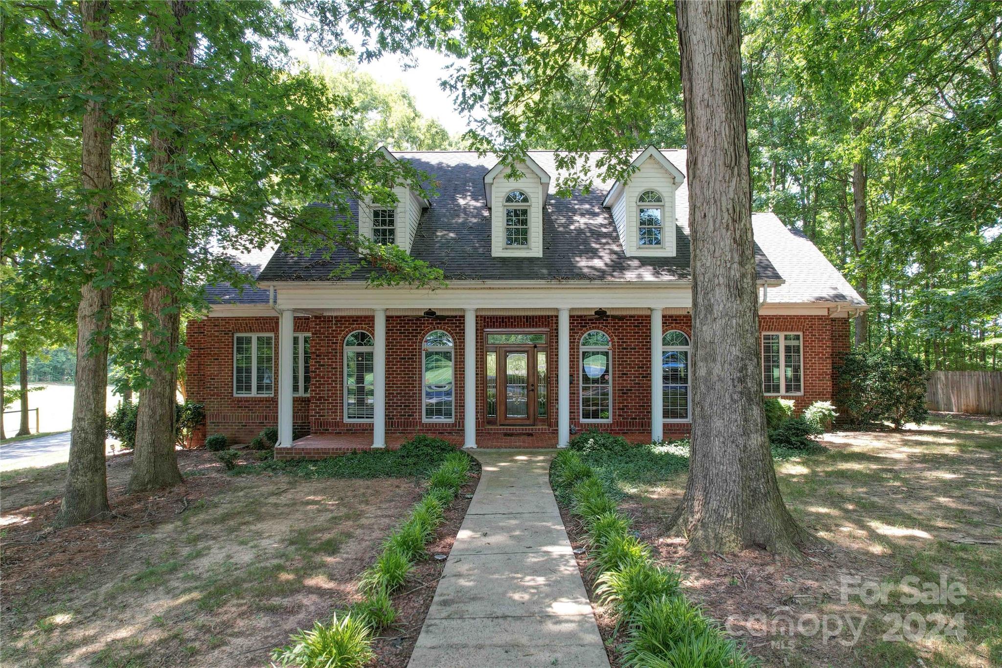 a front view of a house with yard and green space