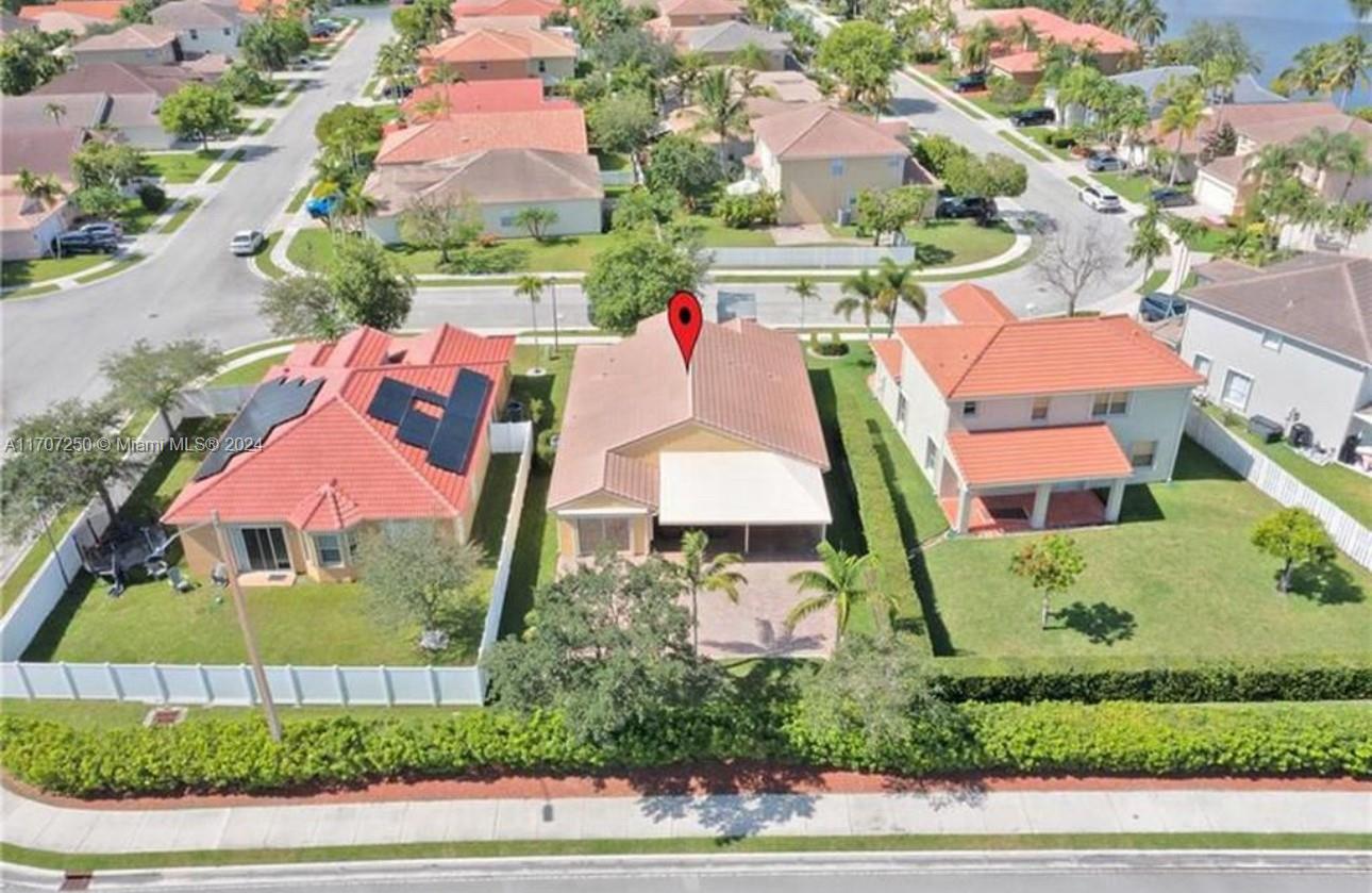 an aerial view of residential houses with outdoor space and parking