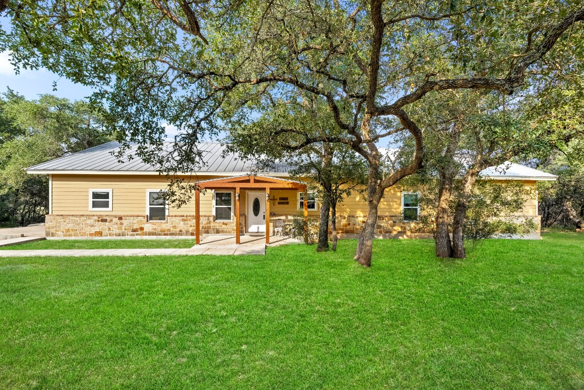 a front view of a house with a garden and trees