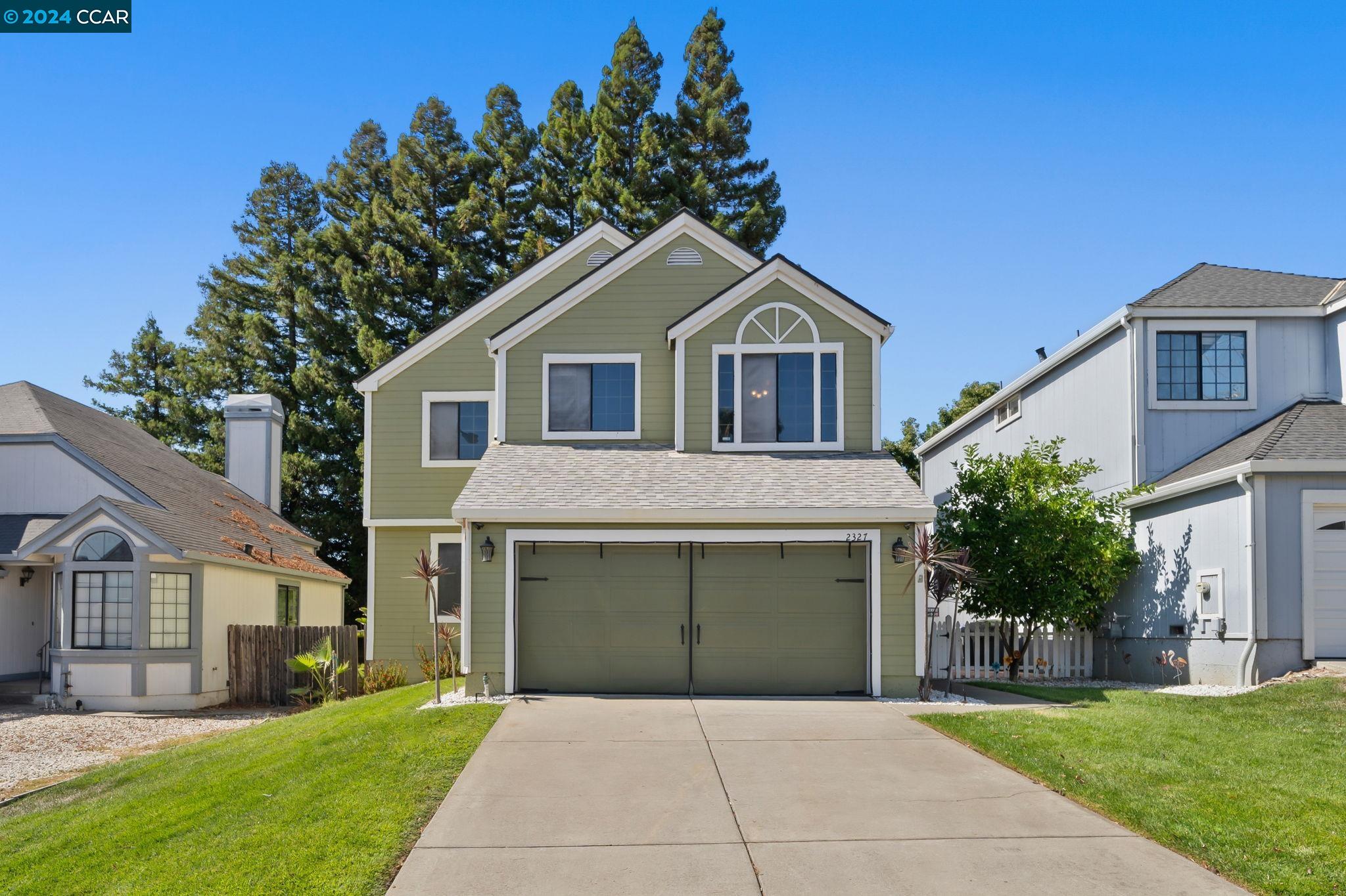 a front view of a house with yard and trees