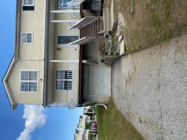 View of front facade featuring a garage, a front lawn, and a porch