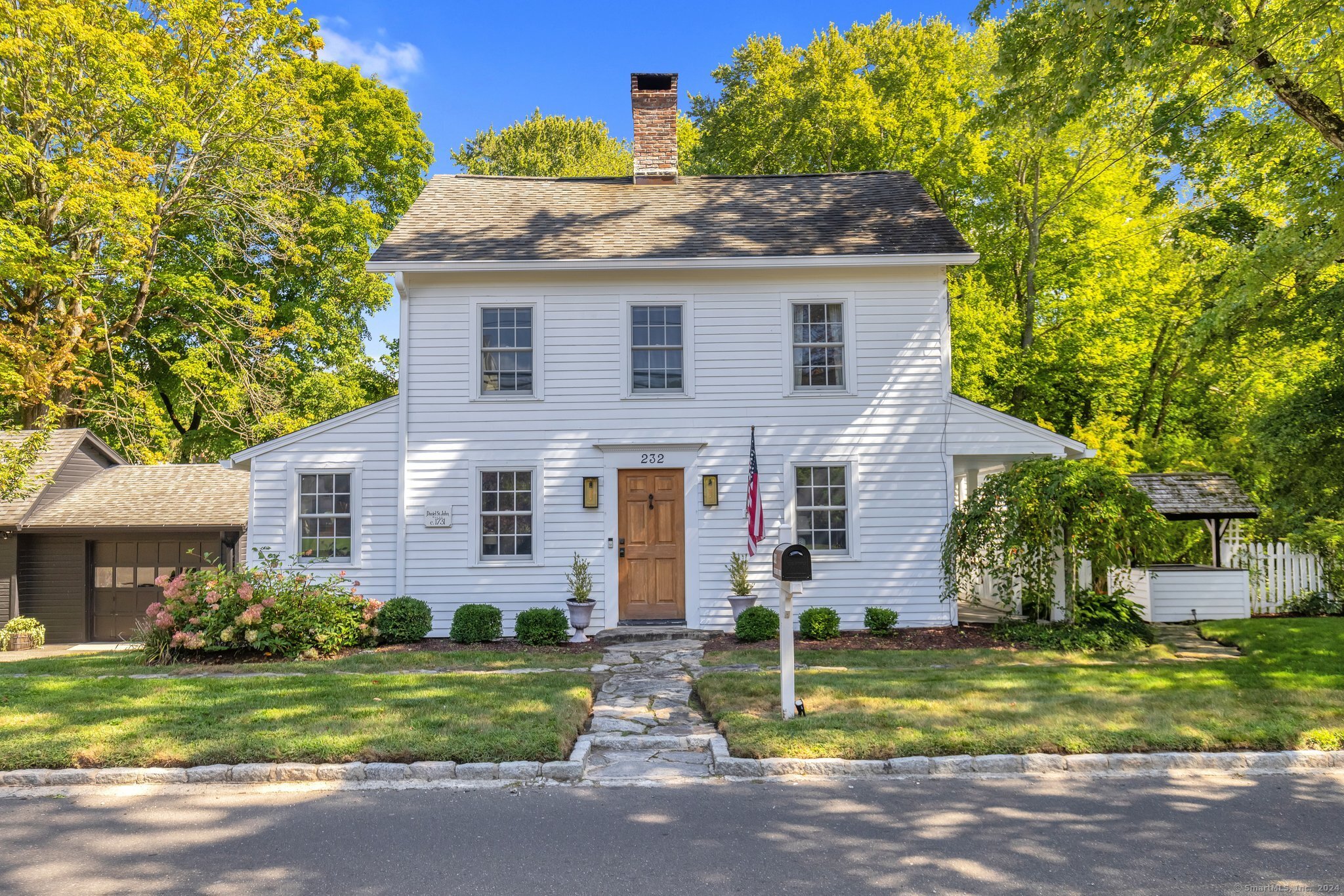 a front view of house with a garden