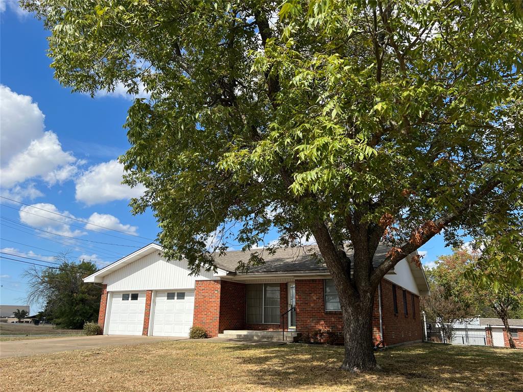 a front view of a house with a tree