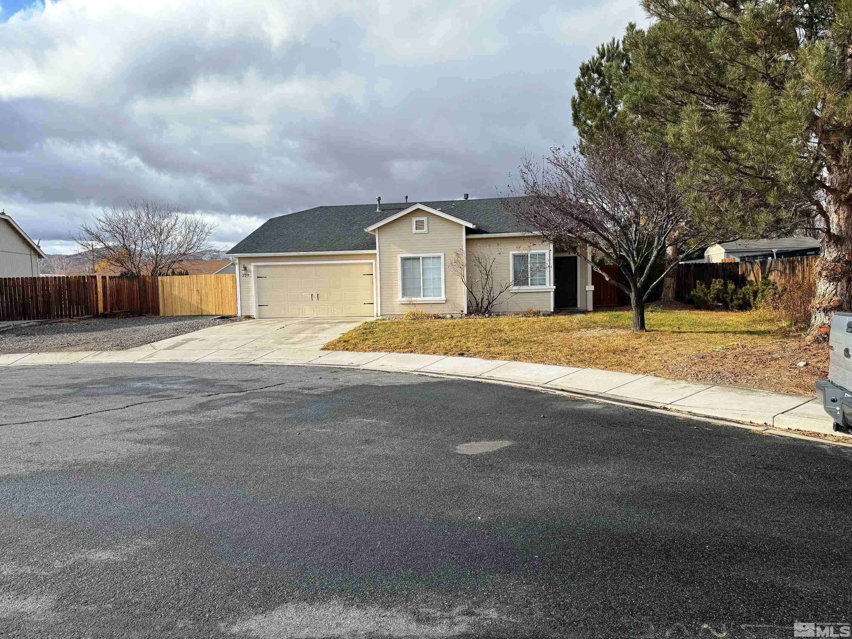 a front view of residential houses with yard and trees