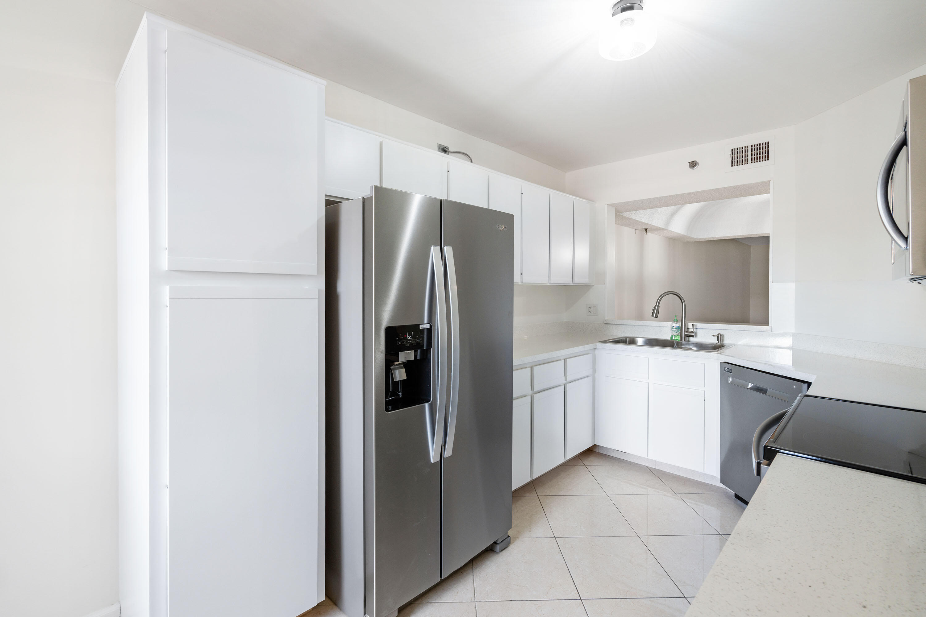 a kitchen with a refrigerator sink and cabinets