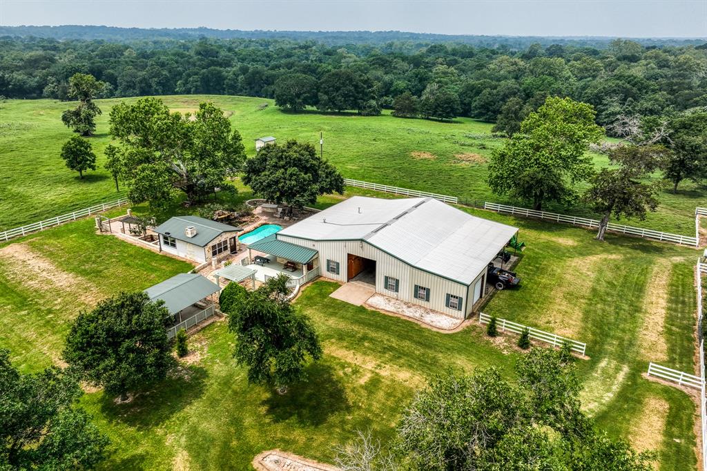 an aerial view of a house with a garden and lake view