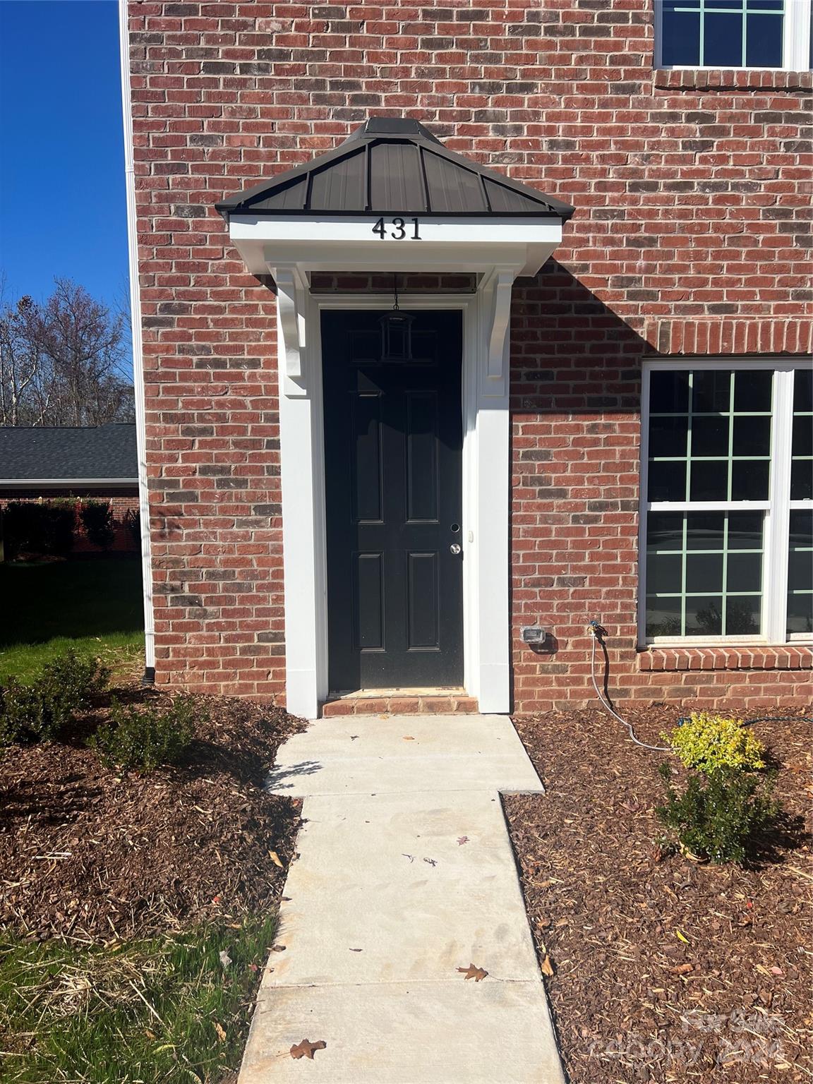 a front view of a house with a garden