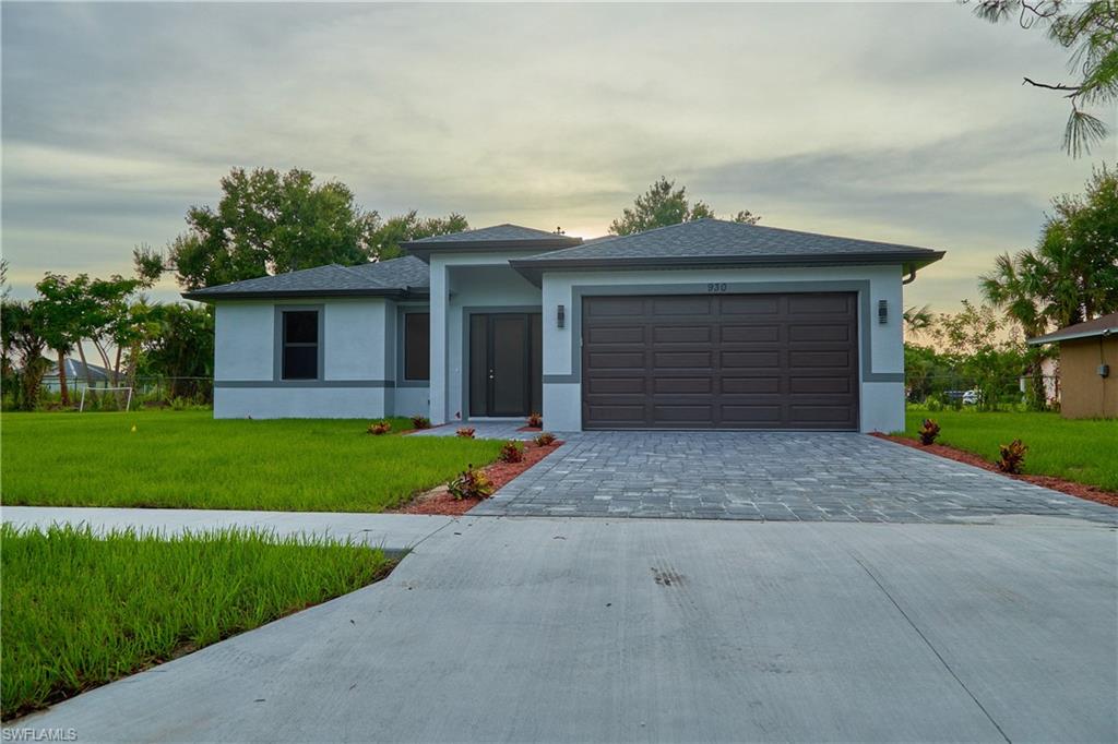 View of front of home featuring a garage and a yard