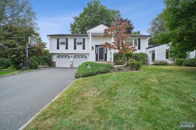 a front view of a house with a yard and trees