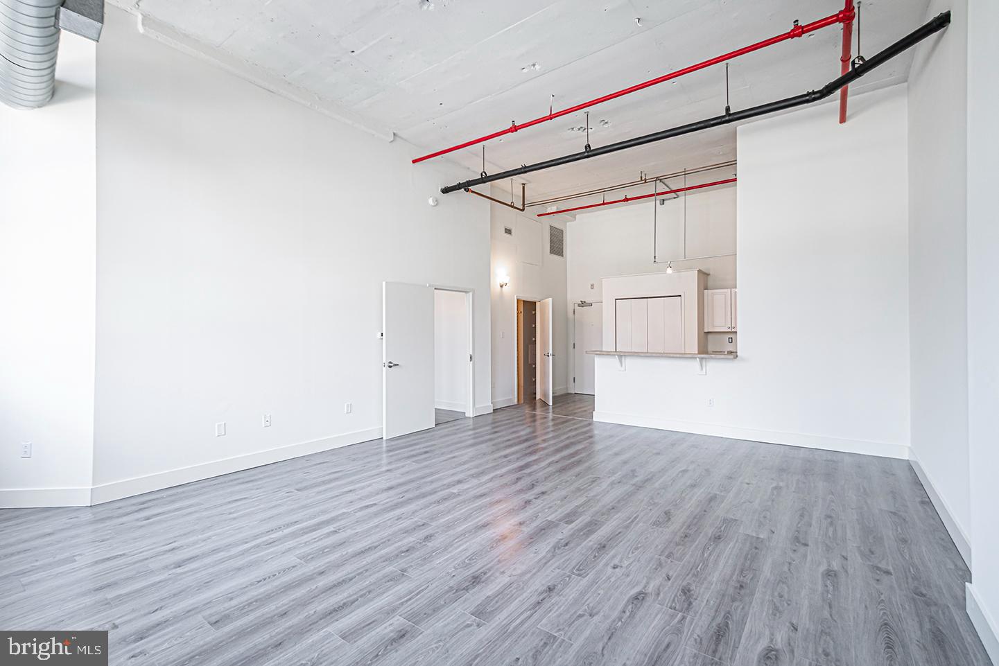 a view of a room with wooden floor and white walls