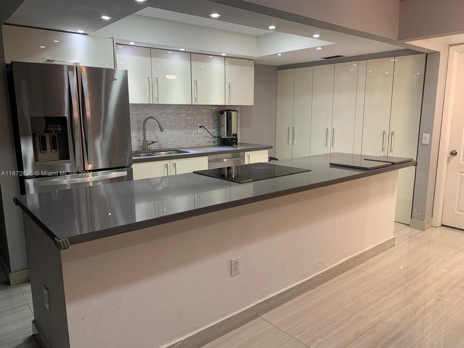 a kitchen with stainless steel appliances granite countertop a sink and a refrigerator