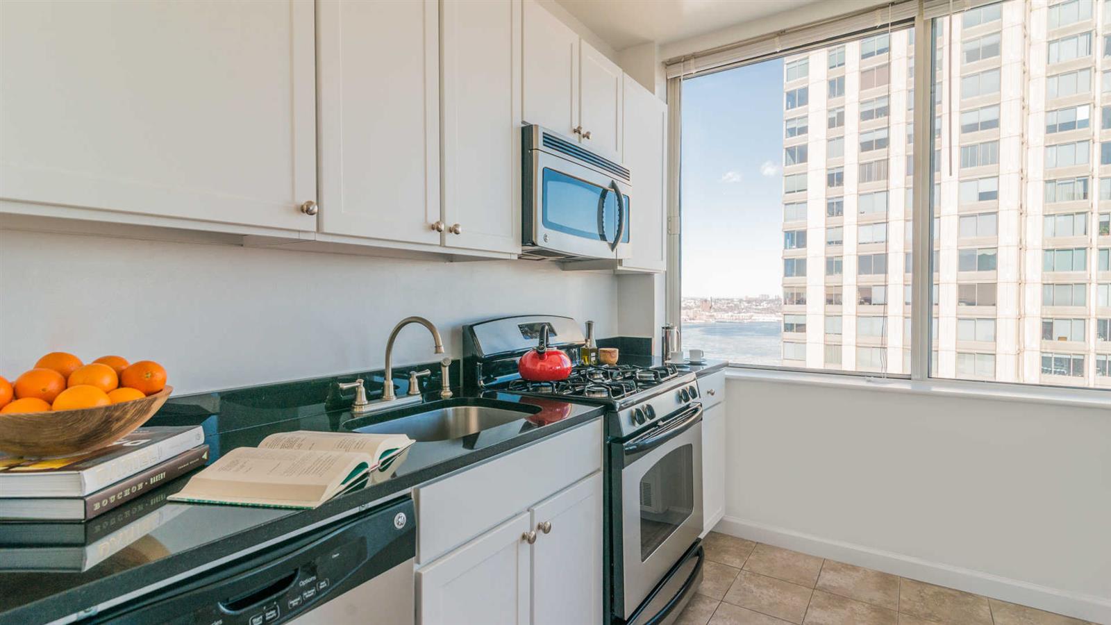 a kitchen with stainless steel appliances granite countertop a sink dishwasher and cabinets with wooden floor