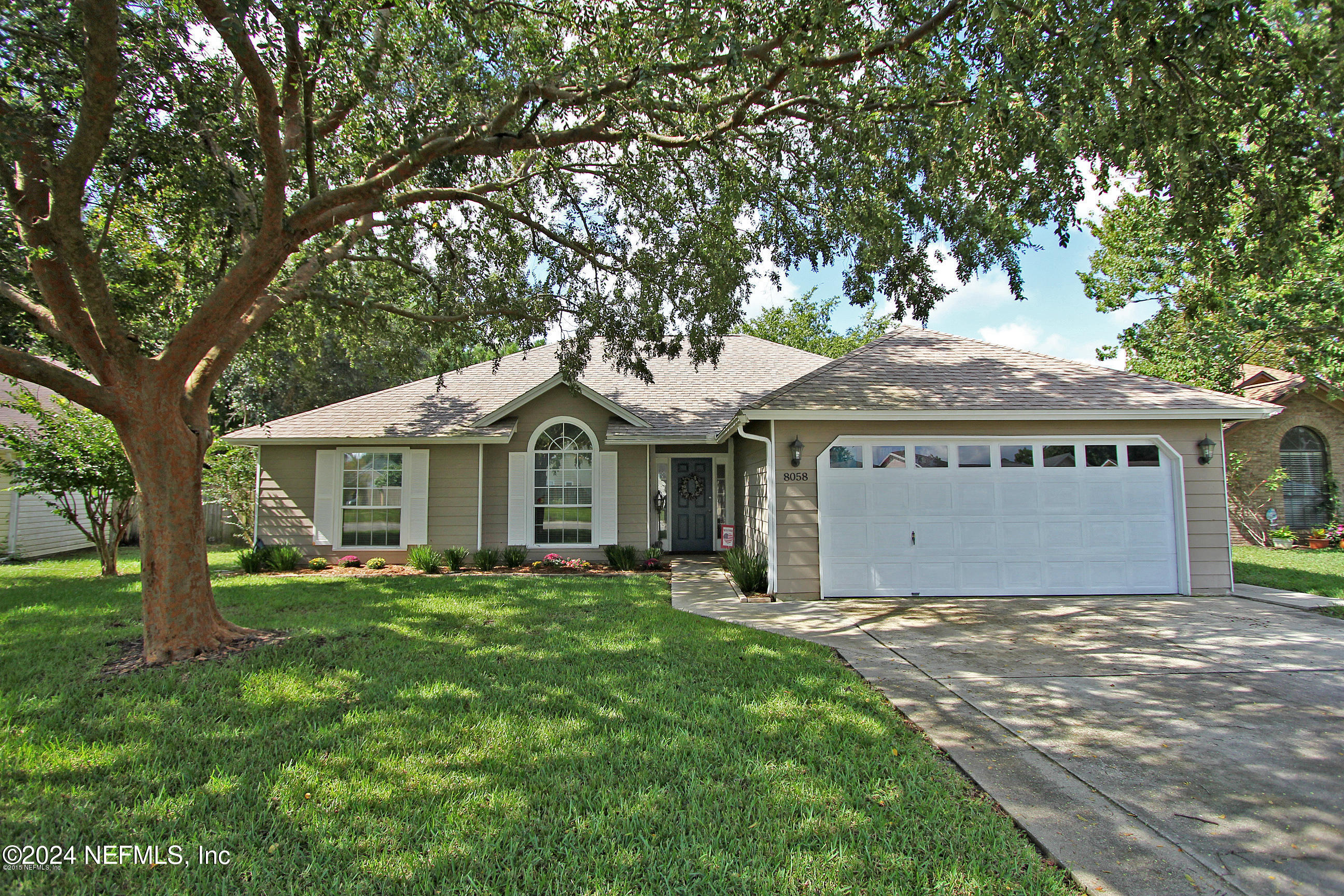 a front view of a house with a garden and yard