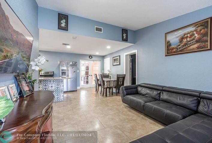 a living room with furniture and a dining table with kitchen view