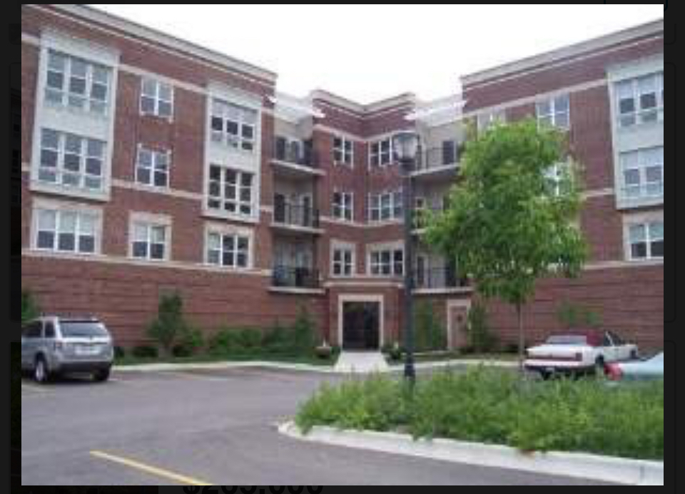 a front view of a building with a garden and plants