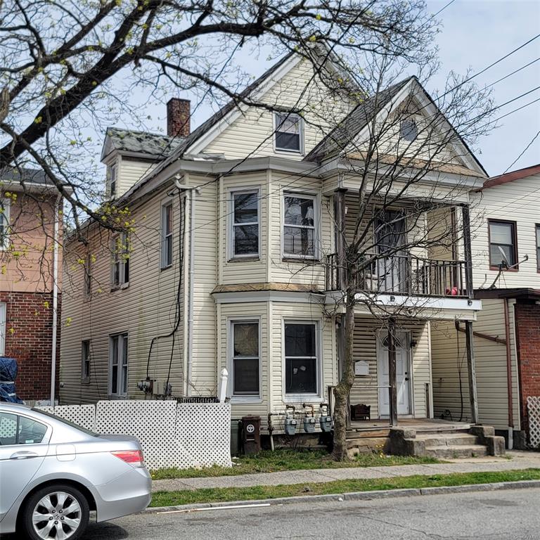 View of front of property with a balcony