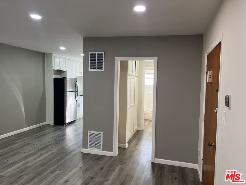 a view of a hallway with wooden floor and closet