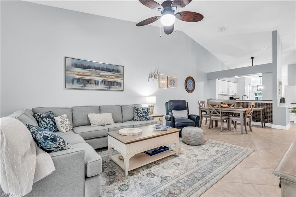 a living room with furniture kitchen view and a chandelier