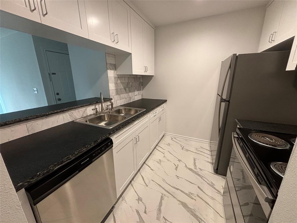 a kitchen with granite countertop a stove and a refrigerator