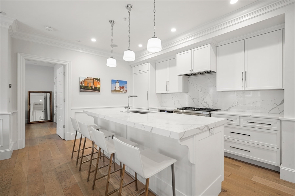 a kitchen with kitchen island a stove a chandelier and a refrigerator