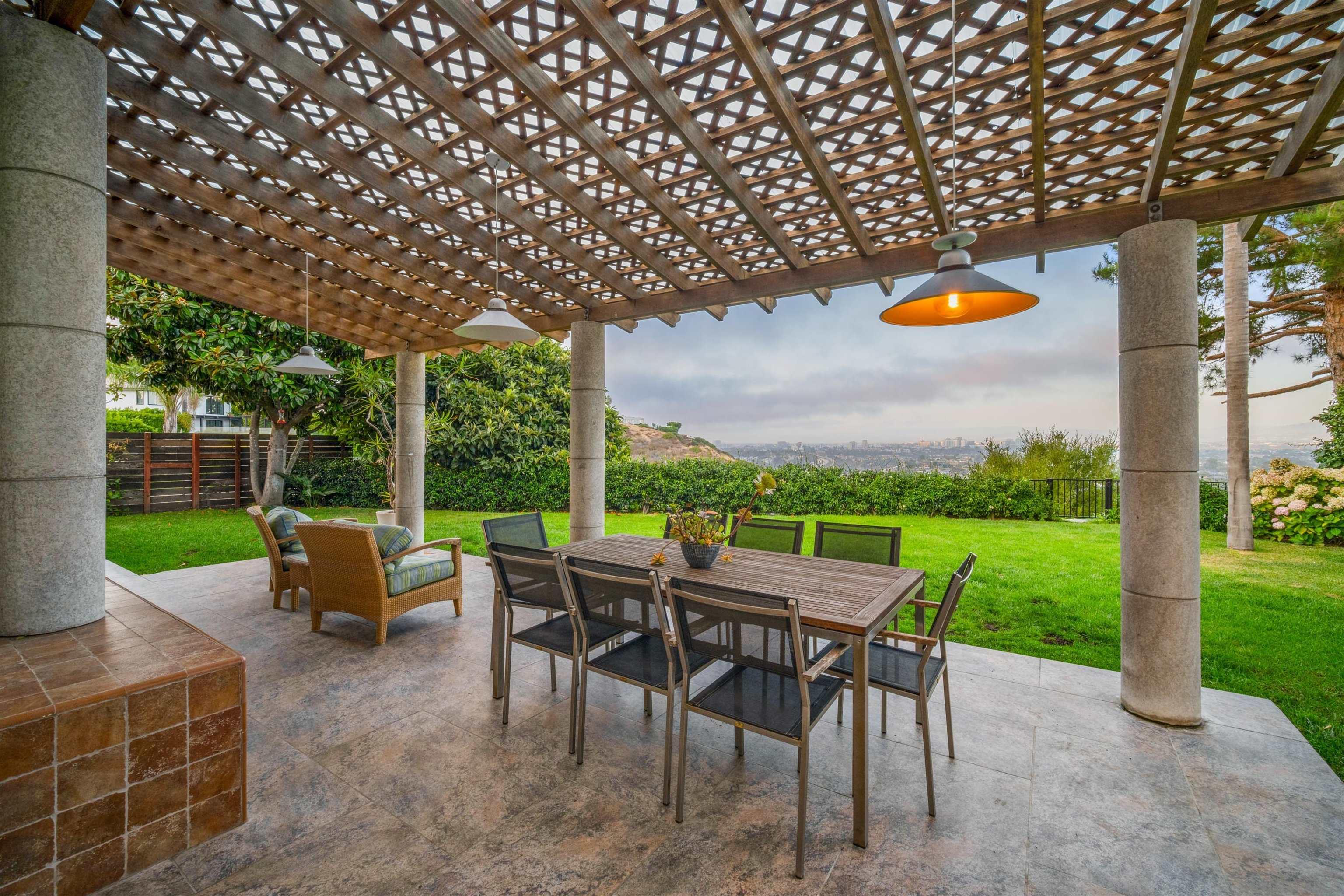 a view of a patio with a table chairs couches and garden view